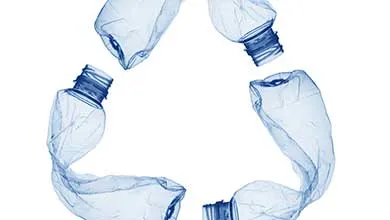 Three crushed blue plastic water bottles arranged in the shape of a recycling symbol on a white background.
